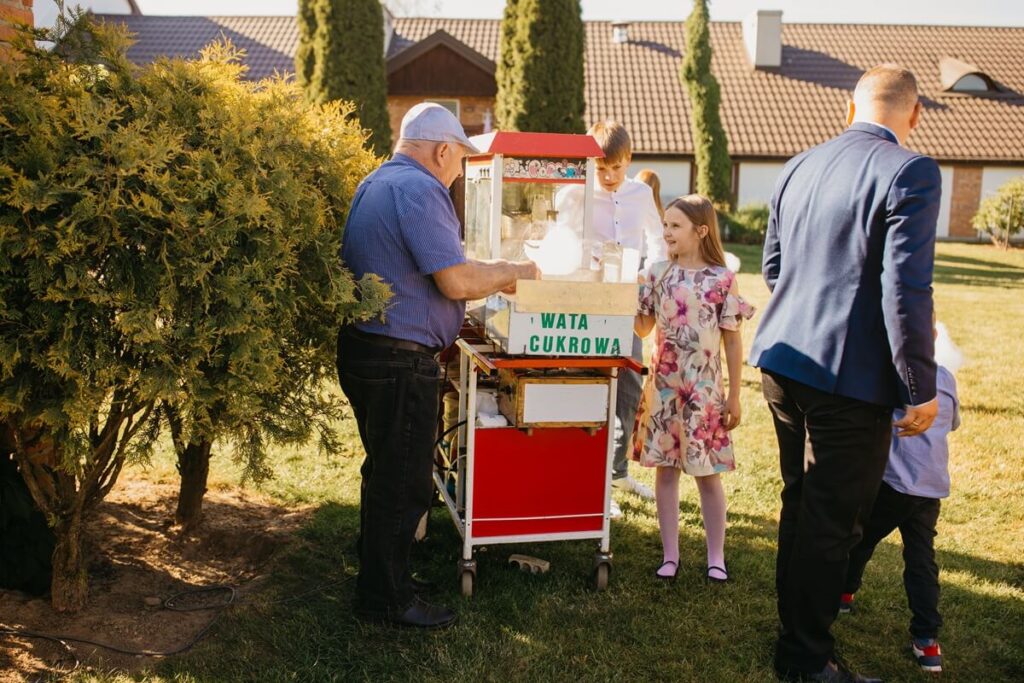 Dzieci odbierające watę cukrową podczas przyjęcia komunijnego